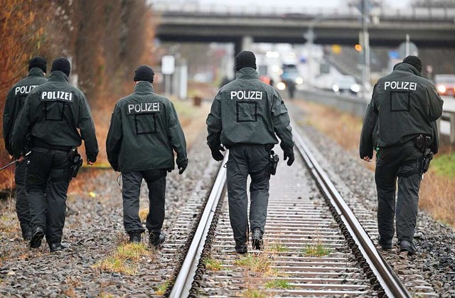 Polizeibeamte nehmen an einem Sucheinsatz an einer Bahnstrecke teil.  | Foto: Marijan Murat (dpa)