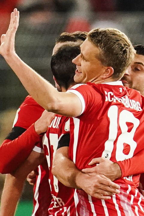 Freiburgs Nils Petersen jubelt mit Mannschaftskollegen über das Tor zum 0:2.  | Foto: Uwe Anspach (dpa)