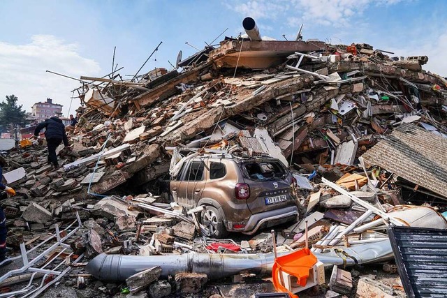 Hatay: Ein Auto steht unter den Trmmern eines zerstrten Gebudes.  | Foto: Ibrahim Oner (dpa)