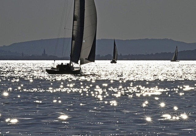 Stimmungsvoll segeln die Boote vor Friedrichshafen auf dem Bodensee.  | Foto: Felix Kstle (dpa)