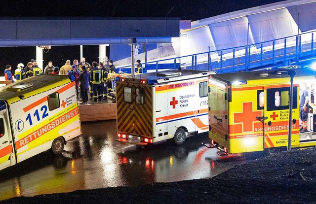 Rettungswagen und Helfer stehen am Ausgang der Bobbahn.  | Foto: Steffen Ittig (dpa)