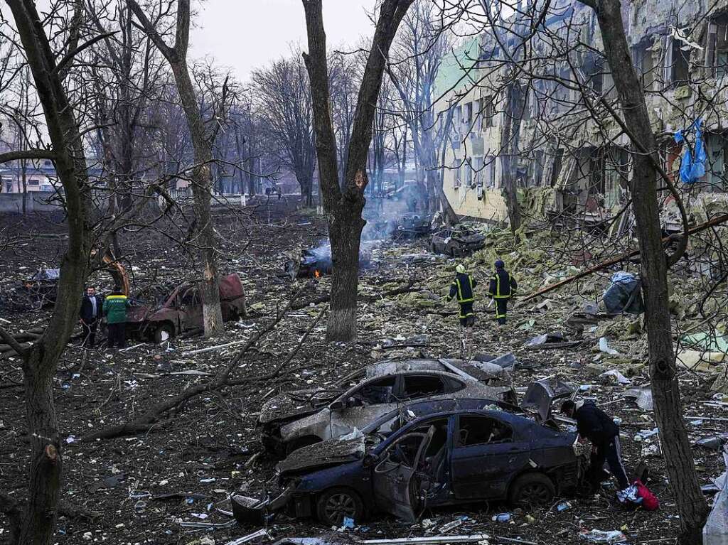 Ukrainische Rettungskrfte gehen an einer durch einen Angriff beschdigten Geburtsklinik in Mariupol vorbei.