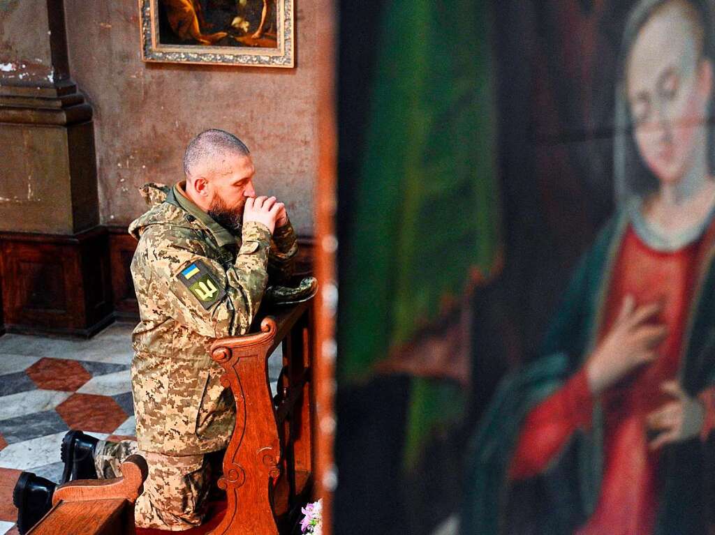 Ein betender ukrainischer Soldat whrend der Beerdigung mehrerer Kameraden in Lviv.