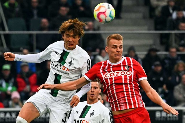 Gladbachs Ko Itakura (l) und Freiburgs Philipp Lienhart kmpfen um den Ball.  | Foto: Federico Gambarini (dpa)