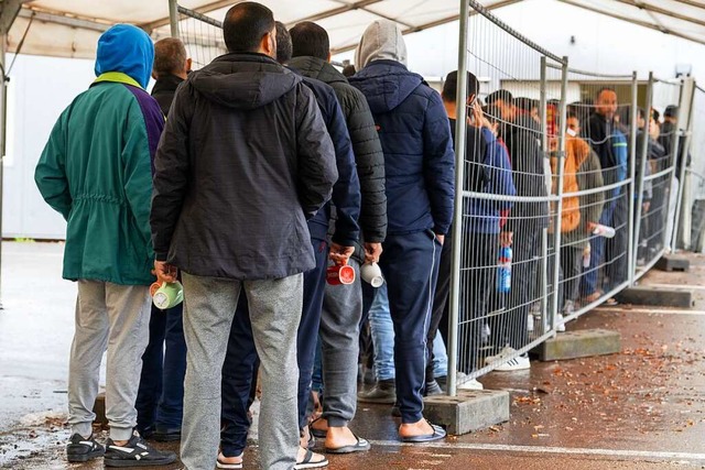 In der Landeserstaufnahmestelle (LEA) ... einer Schlange vor der Essensausgabe.  | Foto: Stefan Puchner (dpa)