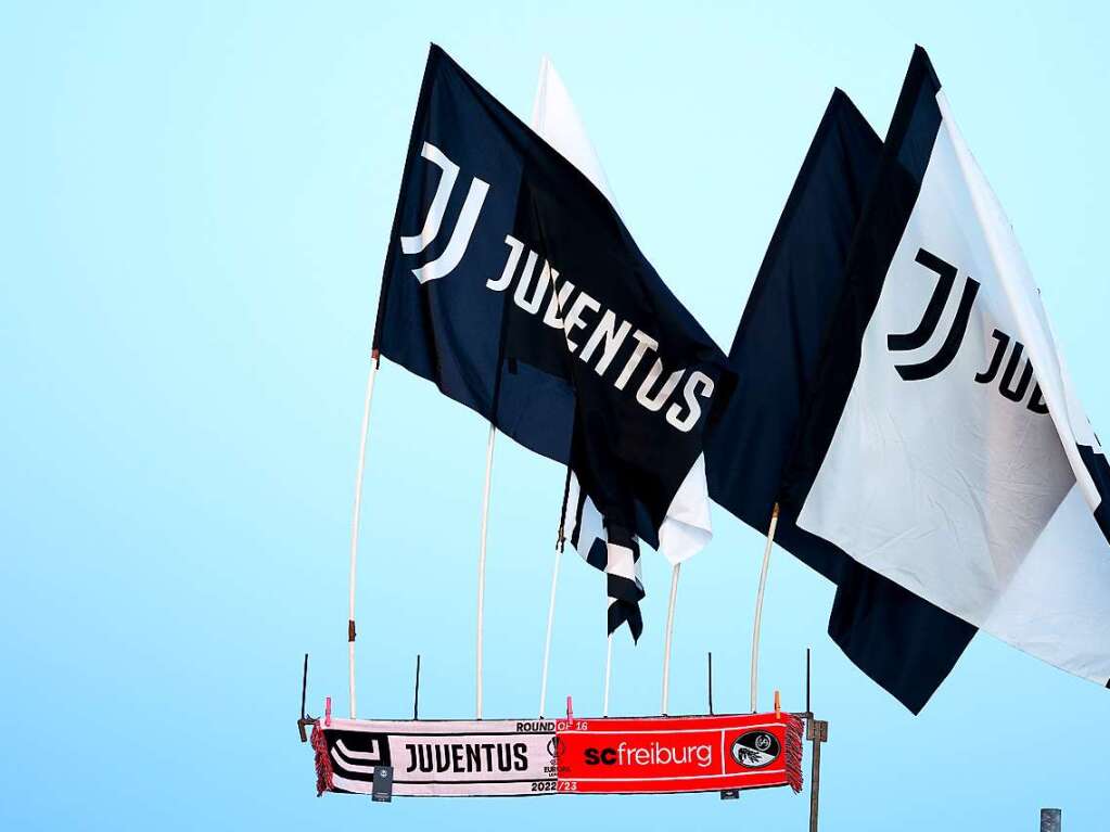 Ein Fanschal zum Spiel und Fahnen von Juventus Turin werden an einem Verkaufsstand angeboten.