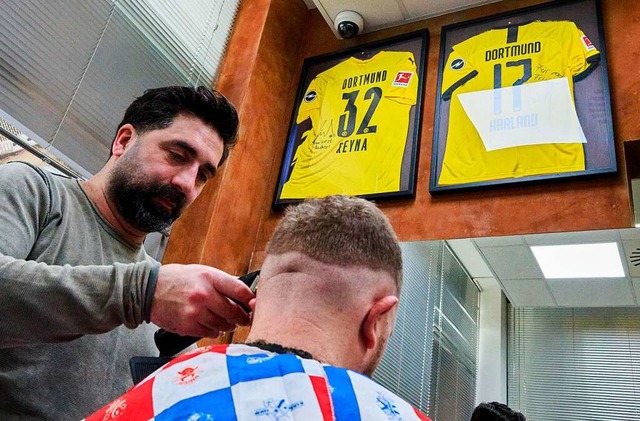 Der Friseur, bei dem Fuballtrikots im Salon hngen: Taner Dogan  | Foto: Bernd Thissen (dpa)