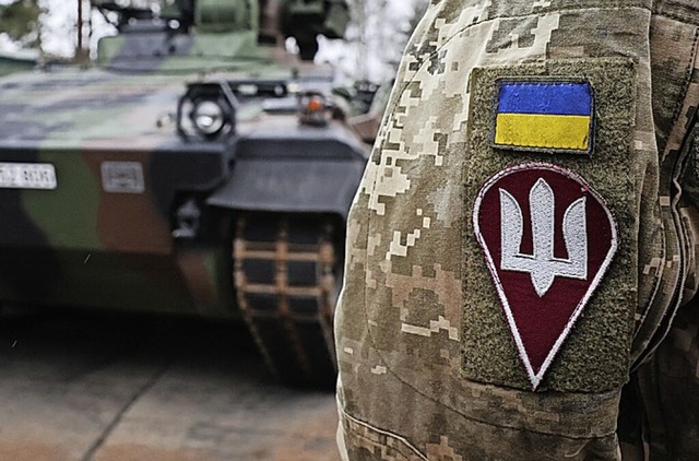 Ein ukrainischer Soldat vor einem deutschen Schtzenpanzer Marder  | Foto: Christian Charisius (dpa)