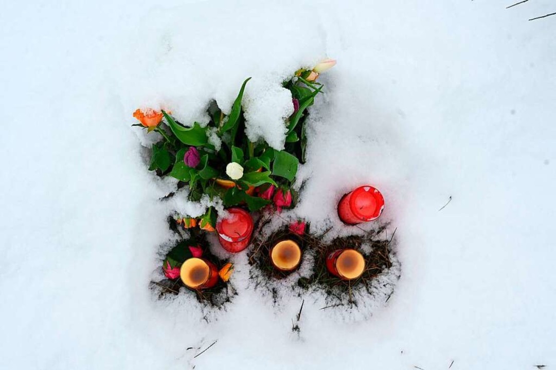 Blumen und Kerzen  stehen im Schnee un...m die Leiche von Luise gefunden wurde.  | Foto: INA FASSBENDER (AFP)