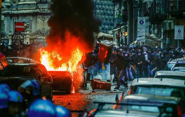 Vermummte Hooligans randalieren in Nea... &#8211; und setzen ein Auto in Brand.  | Foto: Salvatore Laporta (dpa)