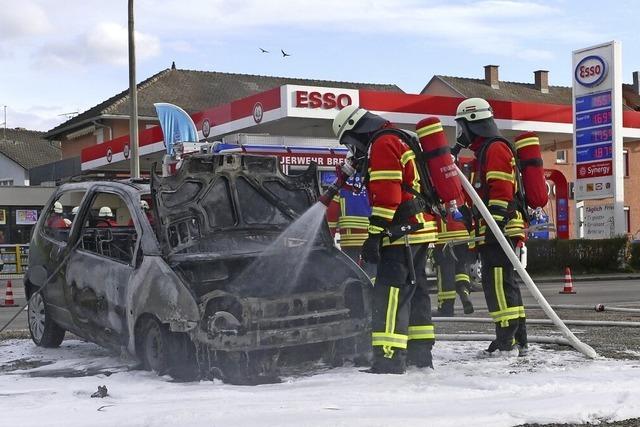 Brennendes Auto weg von Tankstelle geschoben