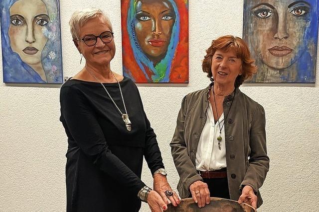 Zwei Frauen zeigen ihre Bilder von Frauen