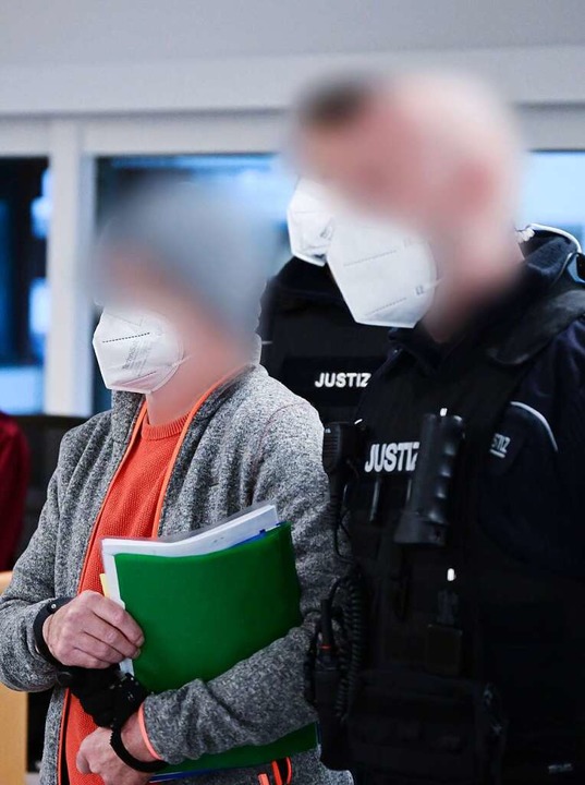Justizvollzugsbeamte führen Manfred J....r Angeklagte trägt stets graue Sachen.  | Foto: Bernd Weißbrod (dpa)