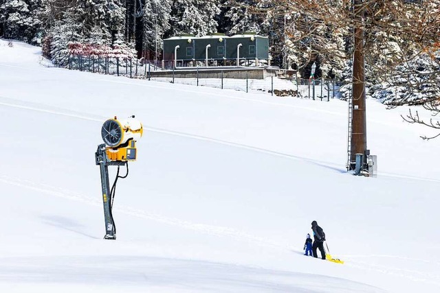 Zwei Menschen ziehen einen Schlitten d... Schnee einen Hang am Feldberg hinauf.  | Foto: Philipp von Ditfurth (dpa)