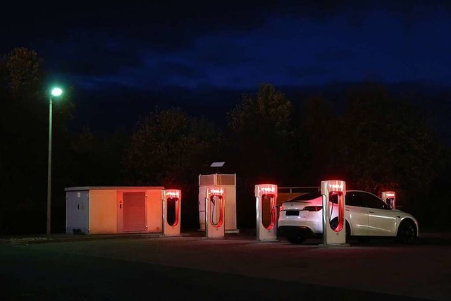 Nur die Ladesulen leuchten: eine Tesla-Station im Dunkeln  | Foto: Steve Przybilla
