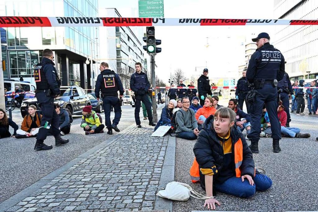 Eine Frau hat sich festgeklebt, rund 2...blockierten darüber hinaus die Straße.  | Foto: Thomas Kunz