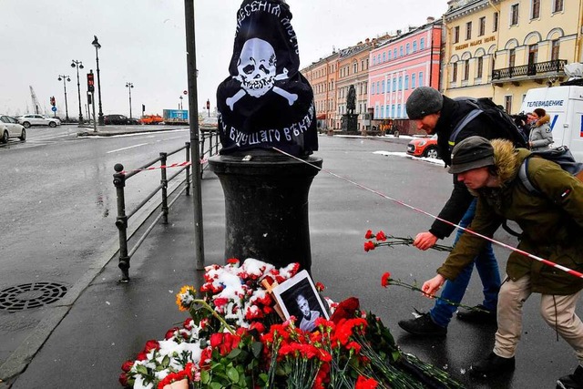 Mnner legen in St. Petersburg Blumen ...nken an den getteten Militr-Blogger.  | Foto: OLGA MALTSEVA (AFP)