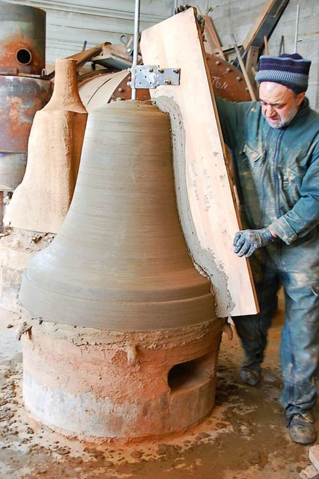 Ein Arbeiter trgt mithilfe eines Holz.../Profil der Glocke ein Tongemisch auf.  | Foto: Brbel Nckles