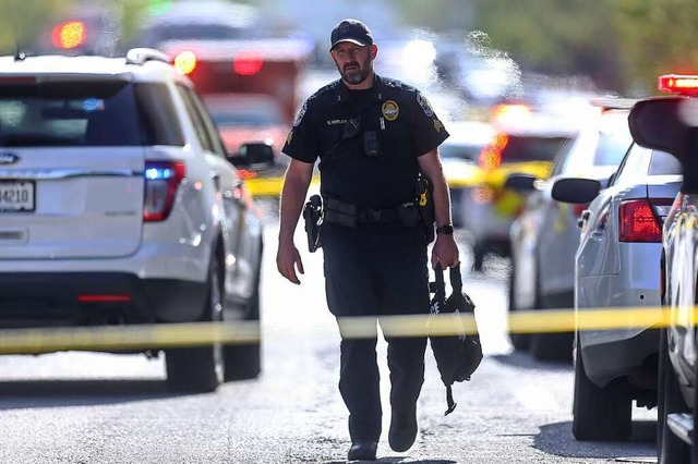 Ein Polizist geht nach dem Schusswaffe...Main Street vor der Old National Bank.  | Foto: Matt Stone (dpa)