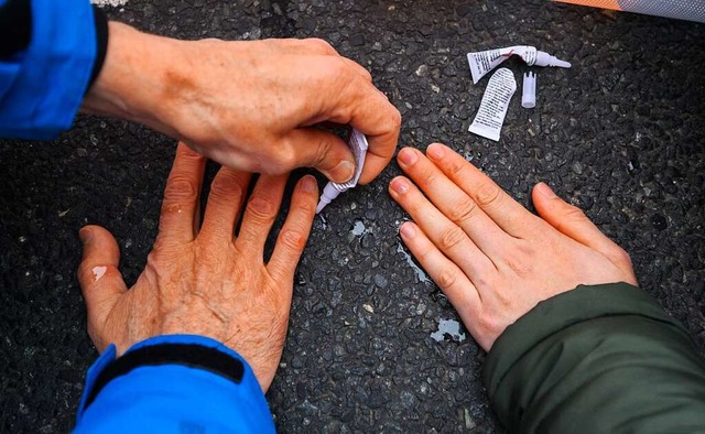 Aktivisten der Letzten Generation kleben sich auf einer Strae fest.  | Foto: Julian Stratenschulte