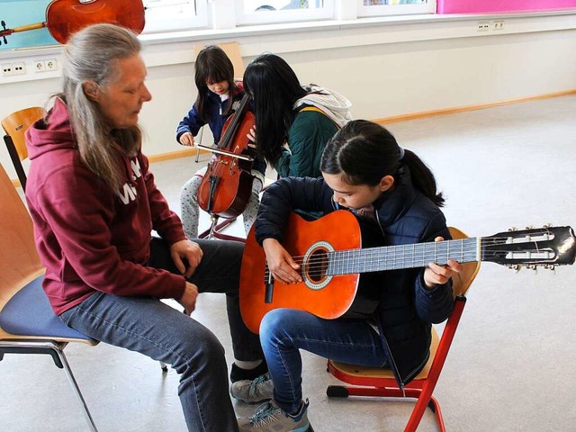 Das Mdchen probiert die Gitarre aus.  | Foto: Marianne Bader