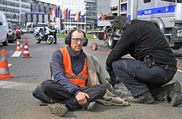 Die Polizei entfernt in Berlin einen A...uppe Letzte Generation von der Strae.  | Foto: TOBIAS SCHWARZ (AFP)