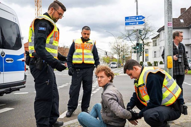 Ein Aktivist bekommt Handschellen ange...fforderungen der Polizei nachzukommen.  | Foto: Hannes P Albert (dpa)