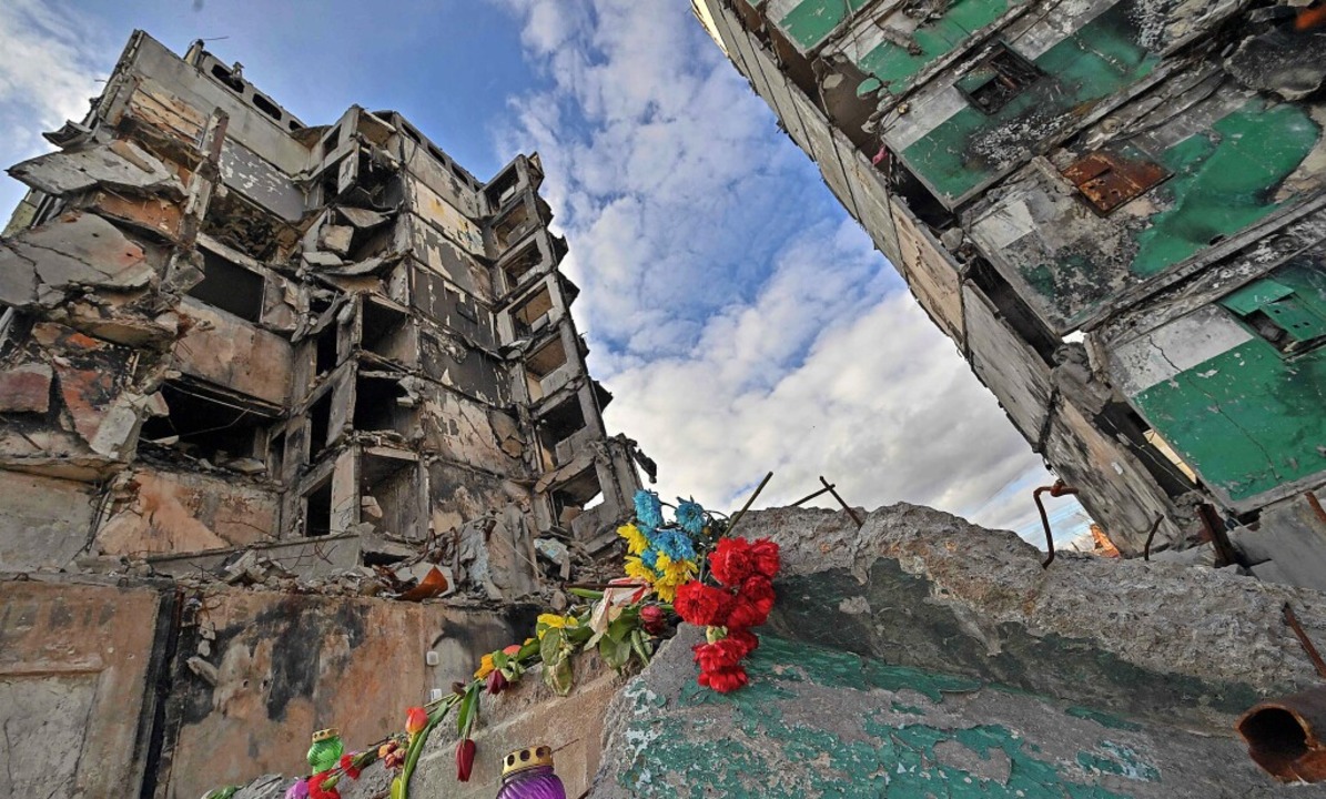 Blumen liegen vor einem Gebäude in der...wurde von russischen Raketen zerstört.  | Foto: SERGEI SUPINSKY (AFP)