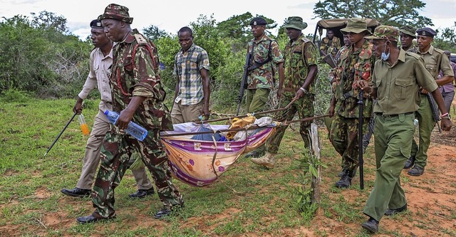 Soldaten und Anwohner tragen exhumierte Leichen der Sekte weg.  | Foto: Uncredited (dpa)