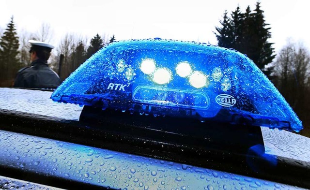 Ein Blaulicht leuchtet im Regen auf dem Dach eines Polizeiwagens.  | Foto: Karl-Josef Hildenbrand (dpa)