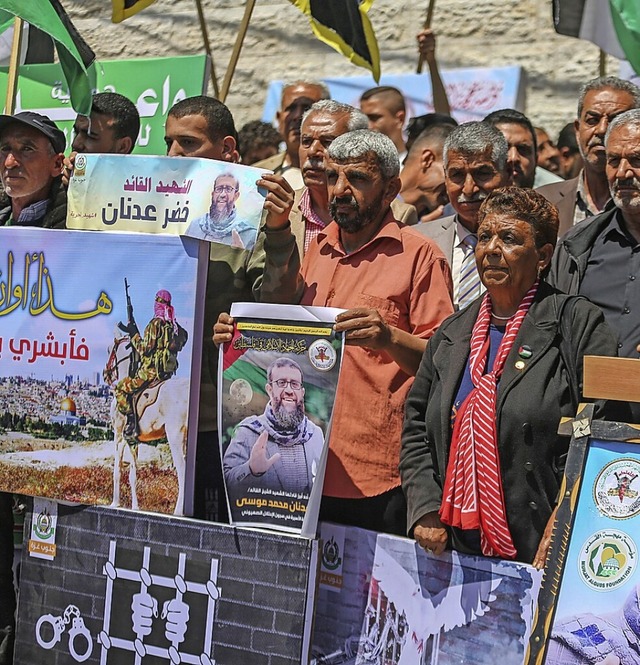 Palstinenser mit Plakaten von  Chader Adnan, der nach einem  Hungerstreik starb  | Foto: Mohammed Talatene (dpa)