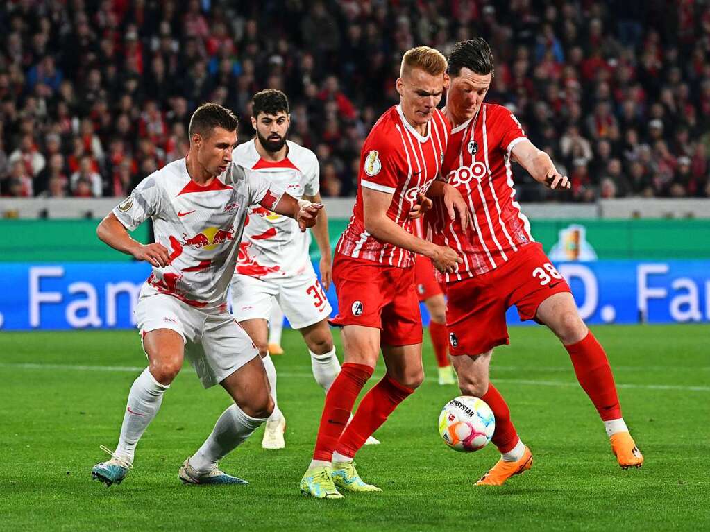 Die Freiburger Michael Gregoritsch  und Philipp Lienhart kmpfen mit Leipzigs Willi Orban  um den Ball.