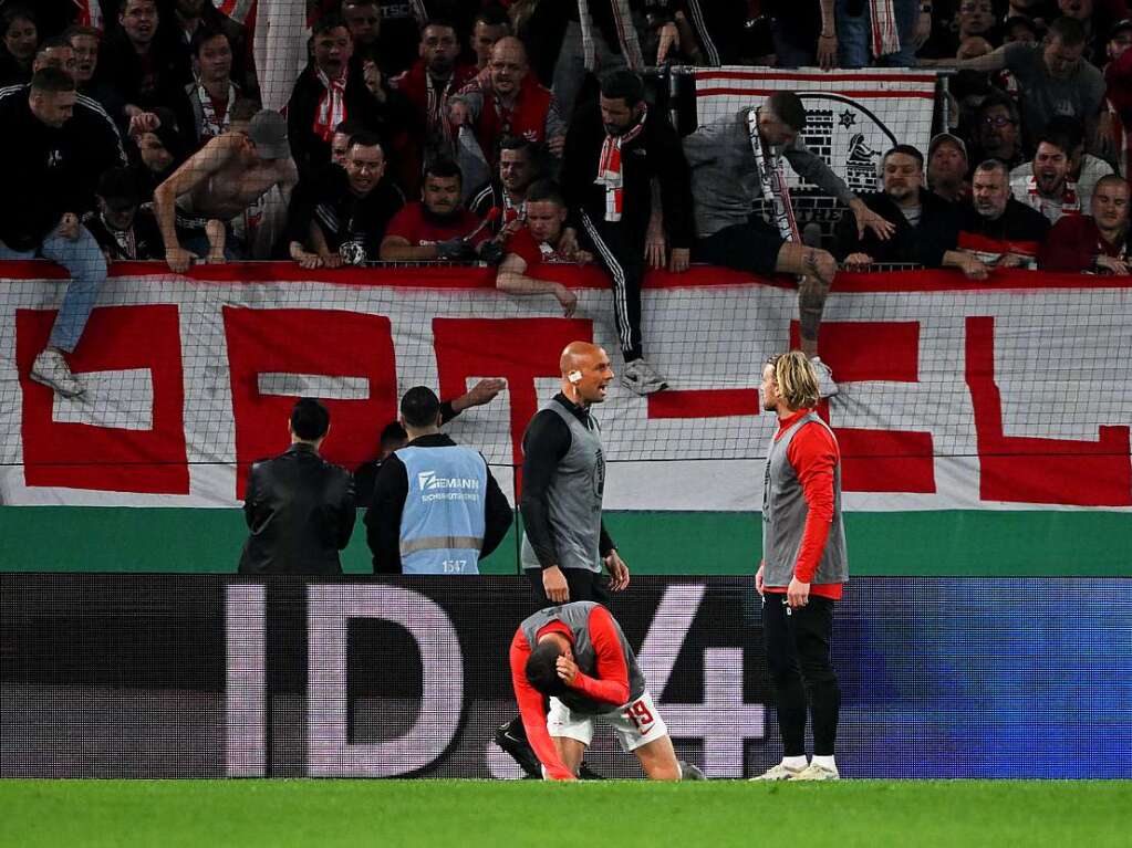 Leipzigs Andre Silva geht vor dem Freiburger Fanblock zu Boden. Neben ihm schaut Leipzigs Emil Forsberg in zu den Fans.