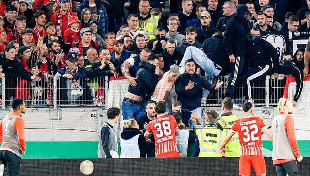 Die SC-Spieler Michael Gregoritsch (38... einiger Freiburger Fans zu beruhigen.  | Foto: THOMAS KIENZLE (AFP)