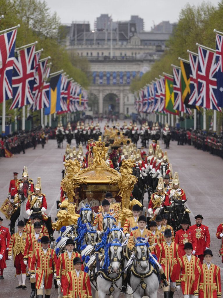 Knig Charles III. und Knigin Camilla sitzen nach der Krnungszeremonie in der goldenen Staatskutsche, die von acht Windsor Greys gezogen wird, auf dem Rckweg zum Buckingham Palace.