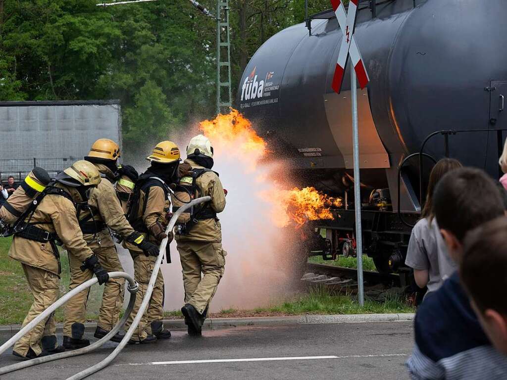 Freiwillige Feuerwehrleute zeigen, wie sie einen Brand bekmpfen, hier am einem Kesselwagen. Das stt auf  sehr groes Interesse.