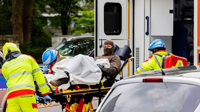 Ein verletzter Polizeibeamter wird vor...chhaus in einen Krankenwagen gebracht.  | Foto: Rolf Vennenbernd (dpa)