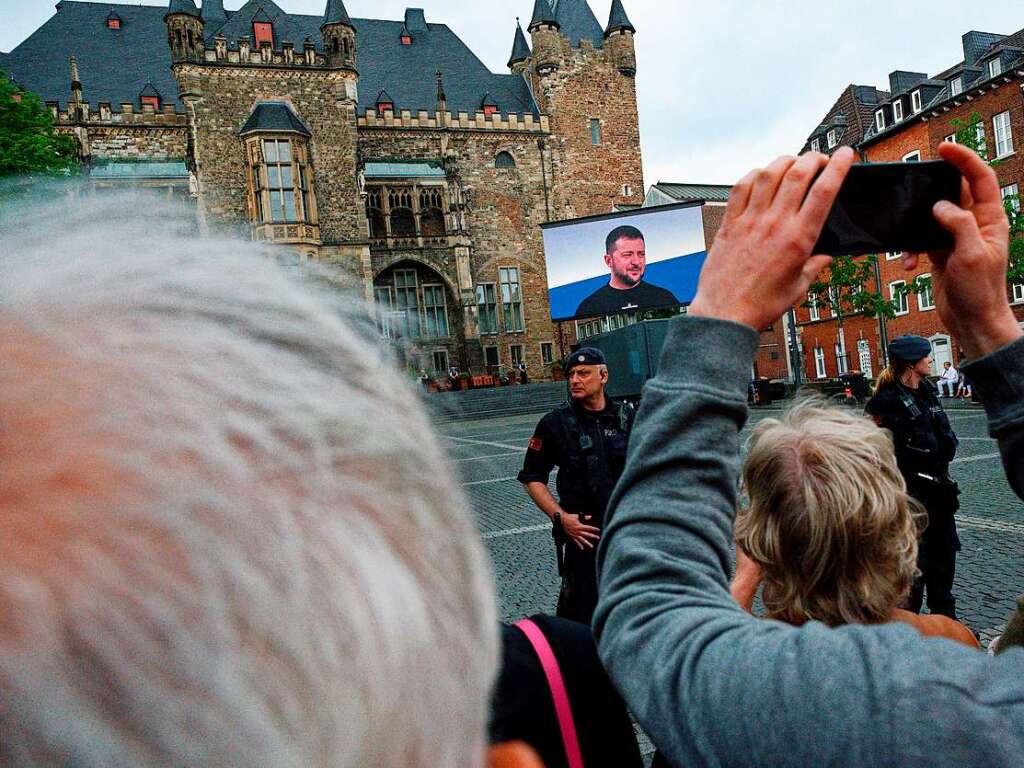 Zuschauer verfolgen die bertragung der Verleihung des Karlspreises auf einer Leinwand auf dem Katschhof.