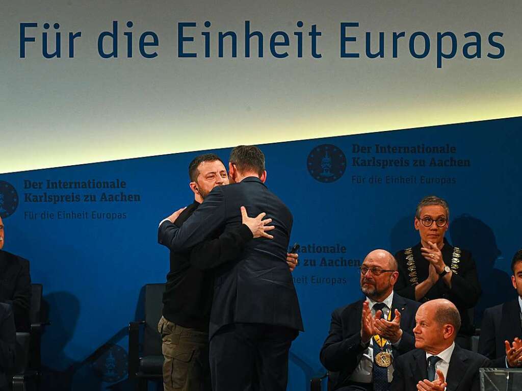 Wolodymyr Selenskyj (Mitte l), Prsident der Ukraine, und Mateusz Morawiecki (Mitte r), Ministerprsident von Polen, umarmen sich bei der Verleihung des Karlspreises im Krnungssaal des Rathauses.