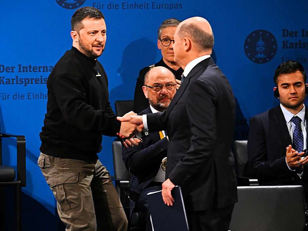 Der ukrainische Prsident Wolodymyr Selenskyj (l) gibt Bundeskanzler Olaf Scholz (SPD) die Hand nach der Laudatio bei der Verleihung des Karlspreises.