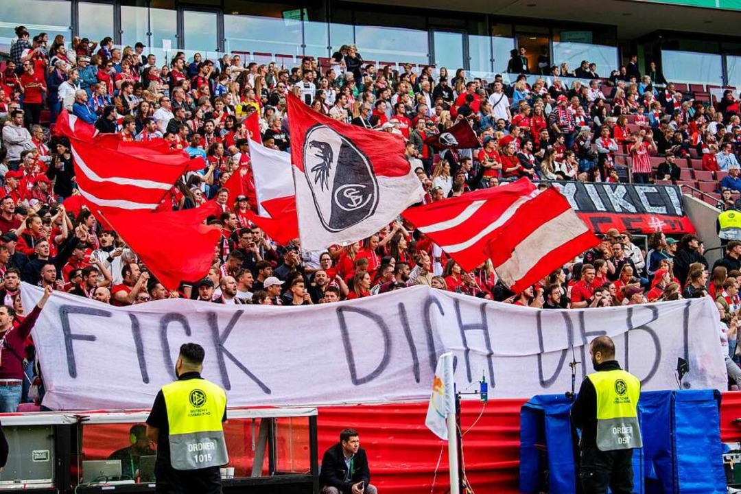 Die Freiburger Fans zeigen ein Banner gegen den DFB.  | Foto: David Inderlied (dpa)