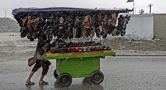 Suche nach Kundschaft: Ein Schuhverku...nen Wagen durch die Straen in Kabul.   | Foto: WAKIL KOHSAR