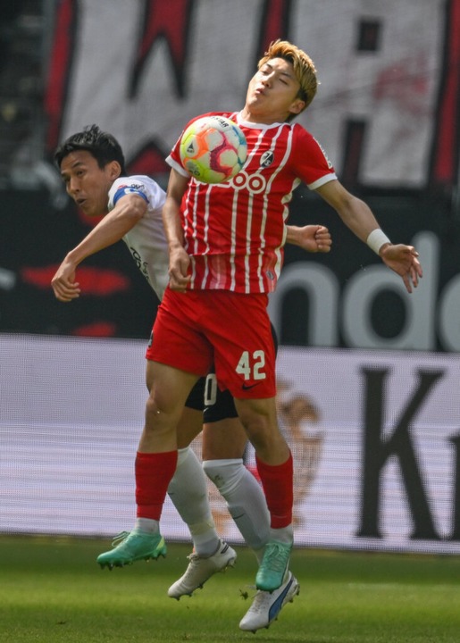 Frankfurts Makoto Hasebe (links) und Freiburgs Ritsu Doan kmpfen um den Ball.  | Foto: Arne Dedert (dpa)