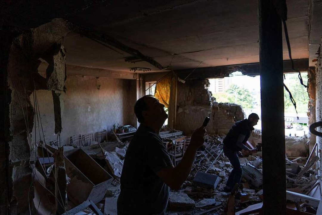 Kiew: Männer inspizieren ihr Büro, das...ff durch eine Drohne beschädigt wurde.  | Foto: Vasilisa Stepanenko (dpa)