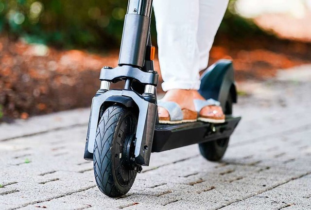 Eine Frau fhrt einen E-Scooter eines Elektro-Tretroller-Sharing-Anbieters.  | Foto: Uwe Anspach (dpa)