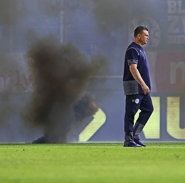 Bielefelds Trainer Uwe Koschinat  vor den Rauchbomben im Stadion  | Foto: Jrg Halisch (dpa)