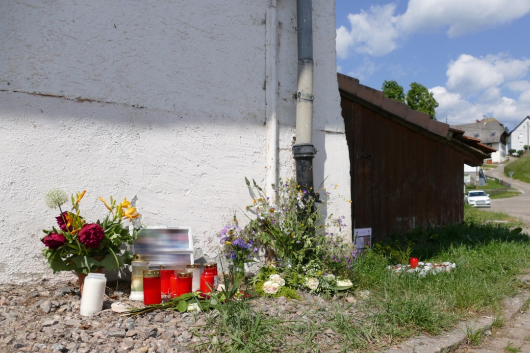 Blumen, Familienfotos und Grablichte w...ohnhaus neben dem Tatort niedergelegt.  | Foto: Stefan Limberger-Andris