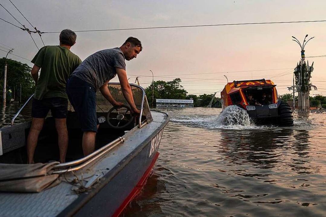 Rettungskräfte evakuieren Menschen in ... überschwemmten Stadtteil von Cherson.  | Foto: Evgeniy Maloletka (dpa)