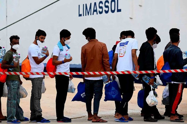 Migranten warten am Hafen der italieni...rt erreichen viele Geflchtete Europa.  | Foto: VINCENZO PINTO (AFP)
