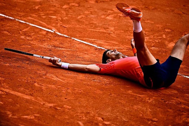 Novak Djokovic liegt nach seinem Finalsieg glcklich im Sand.  | Foto: JULIEN DE ROSA (AFP)